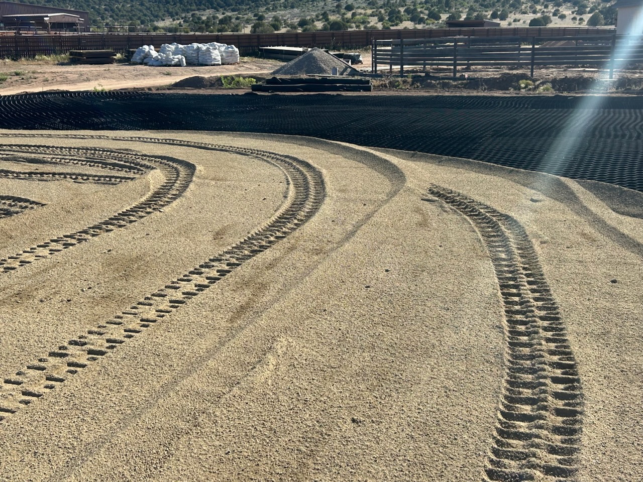 Prescott AZ Geocell Base & Aggregate Compacted aggregate base over geocell grid for an outdoor riding arena in Prescott, Arizona with high desert mountain backdrop